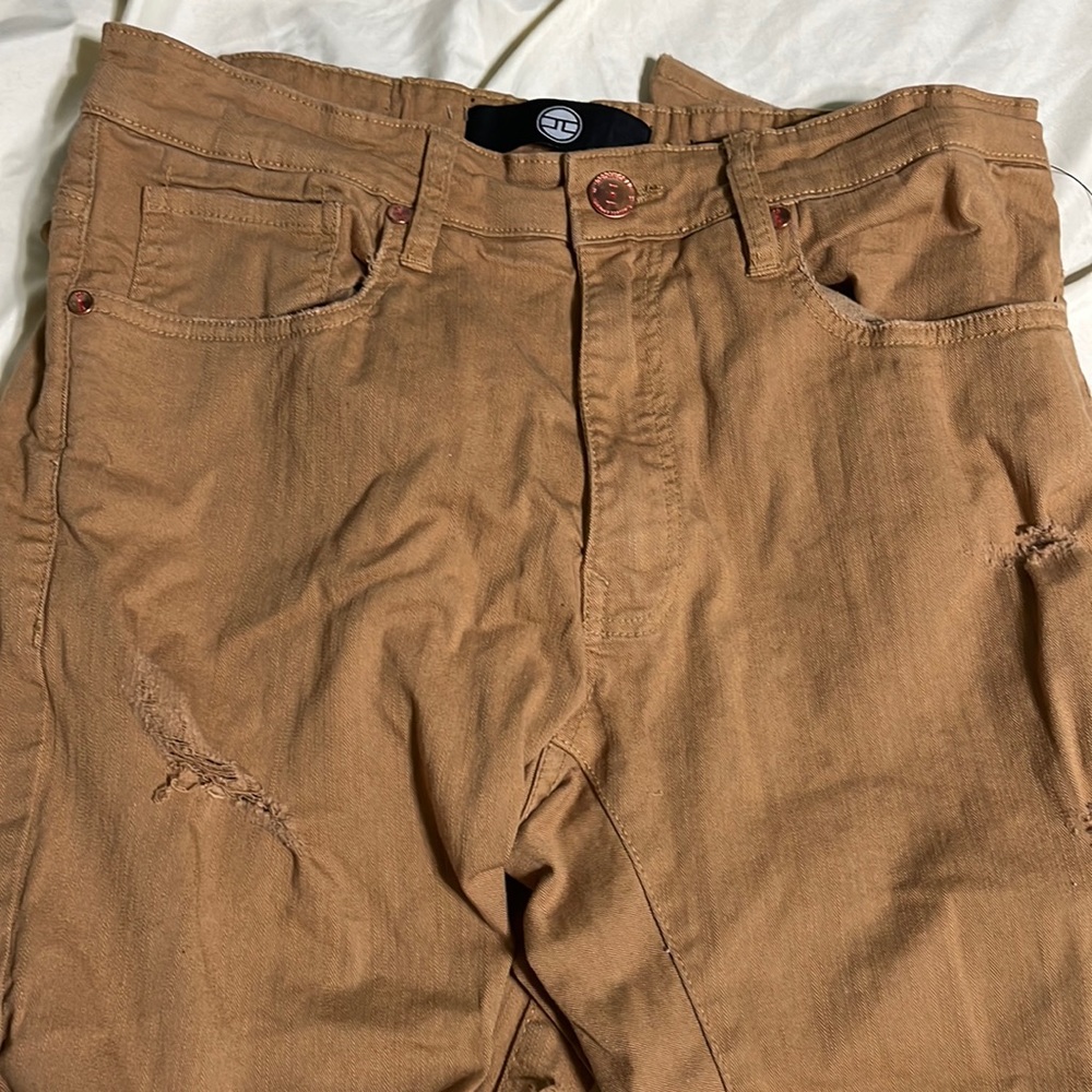 An orange-ish brown ripped Jean, mens 32/32